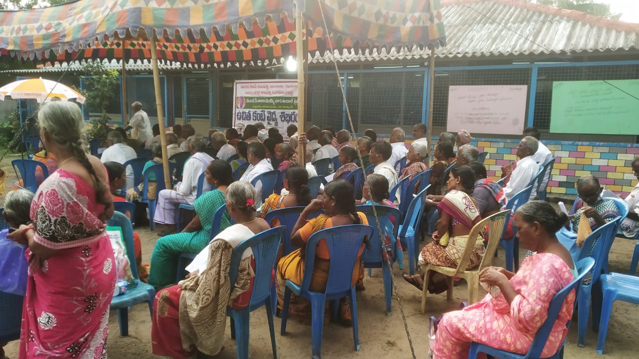Wide view of a large turnout under a canopy at a community eye camp