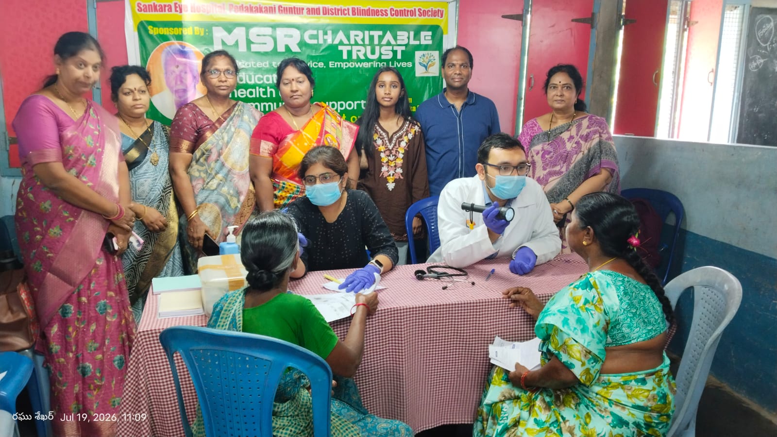 Medical professionals examining patients with flashlights at an eye screening camp with Sankara Eye Hospital